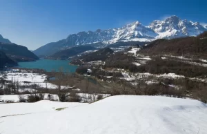 Paisaje nevado del Valle de Tena con montañas y embalse al fondo, ideal para disfrutar de actividades invernales en el Valle de Tena
