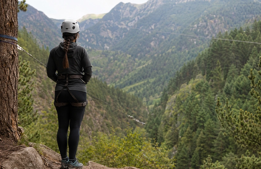 Persona preparándose para afrontar el miedo a la tirolina antes de realizar el salto en un entorno de montaña